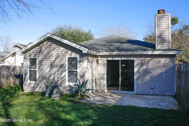 back of property with a yard and a patio