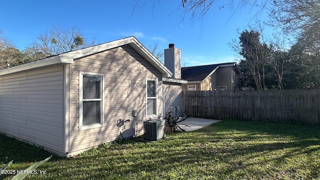 view of home's exterior with central AC and a yard