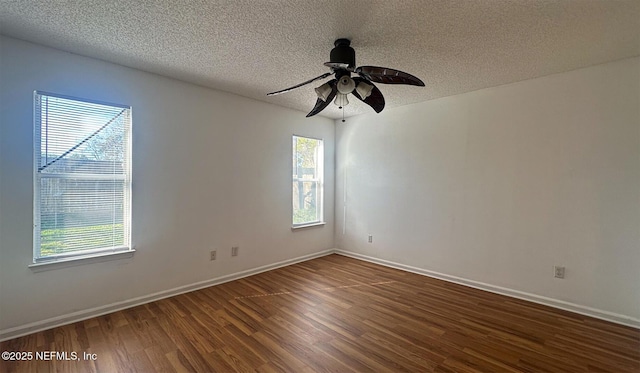 spare room featuring ceiling fan, a wealth of natural light, dark hardwood / wood-style floors, and a textured ceiling