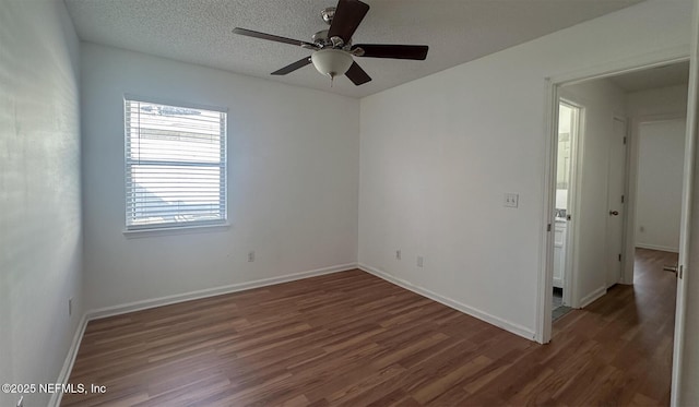 empty room featuring a textured ceiling, dark hardwood / wood-style floors, and ceiling fan