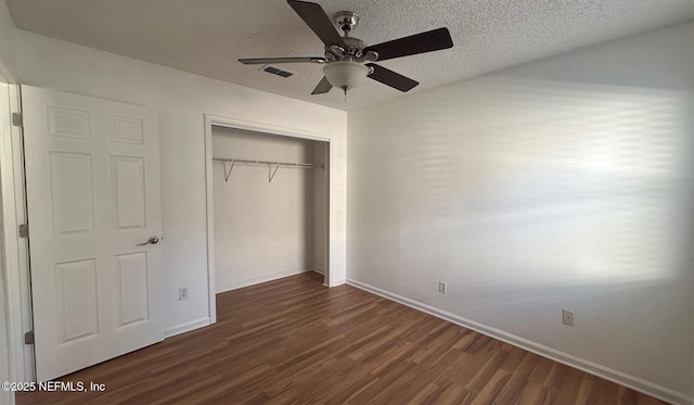 unfurnished bedroom with a textured ceiling, dark hardwood / wood-style floors, a closet, and ceiling fan