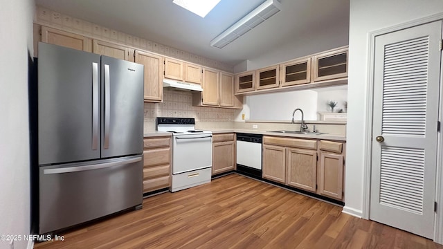 kitchen with light brown cabinetry, sink, light wood-type flooring, white appliances, and decorative backsplash