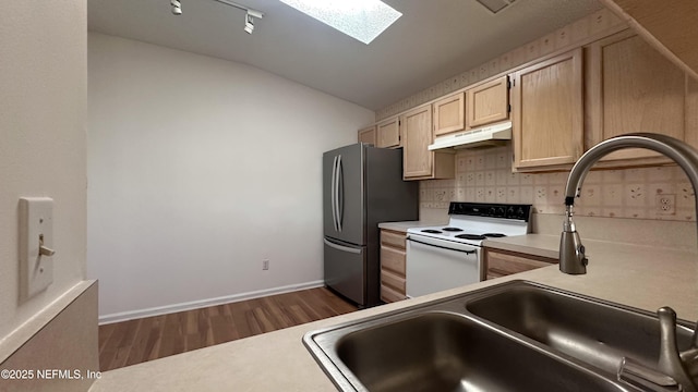 kitchen with electric stove, stainless steel refrigerator, lofted ceiling with skylight, backsplash, and light brown cabinets