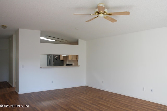 unfurnished living room with ceiling fan, a textured ceiling, dark hardwood / wood-style floors, and vaulted ceiling