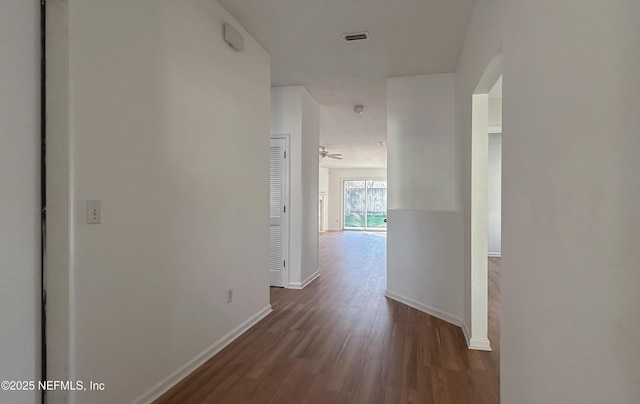 corridor with hardwood / wood-style floors