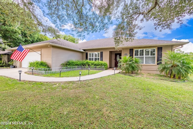 ranch-style house featuring a garage and a front yard