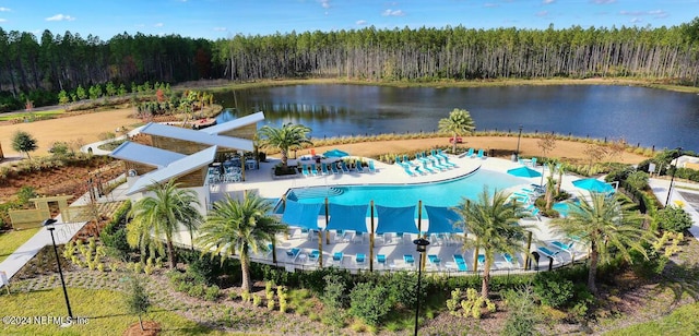 community pool with a water view, a forest view, and a patio area