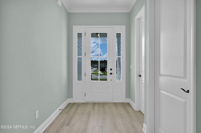 doorway featuring crown molding, light wood-style flooring, and baseboards