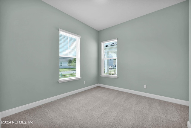 carpeted spare room featuring baseboards