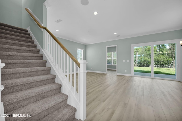 stairs with crown molding, recessed lighting, visible vents, wood finished floors, and baseboards