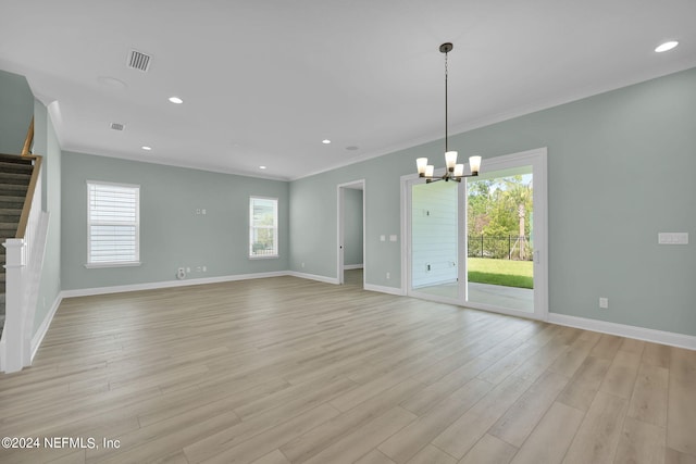 unfurnished living room featuring baseboards, stairway, crown molding, light wood-style floors, and a chandelier