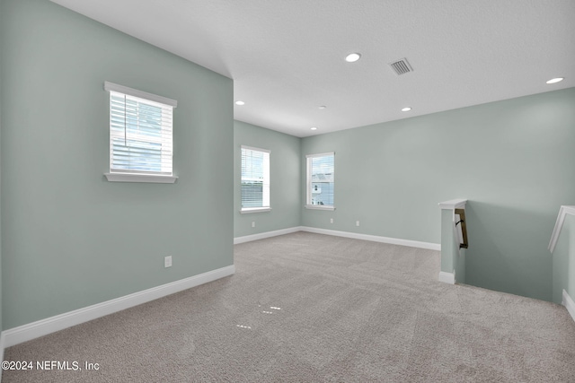 carpeted empty room featuring recessed lighting, visible vents, and baseboards