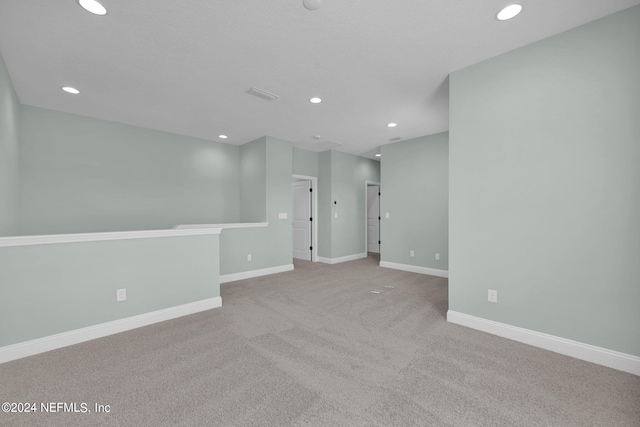 carpeted spare room featuring recessed lighting, visible vents, and baseboards