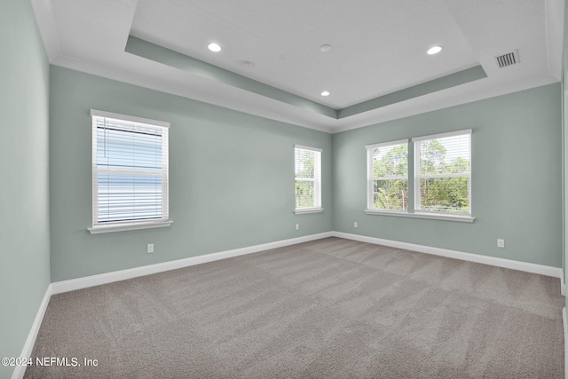 carpeted spare room with recessed lighting, a raised ceiling, visible vents, and baseboards