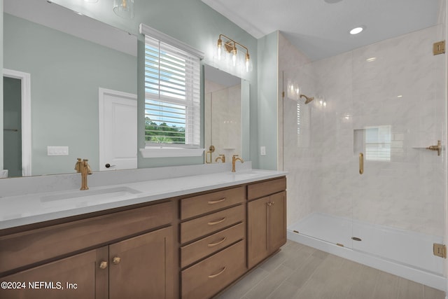 bathroom with double vanity, a shower stall, and a sink