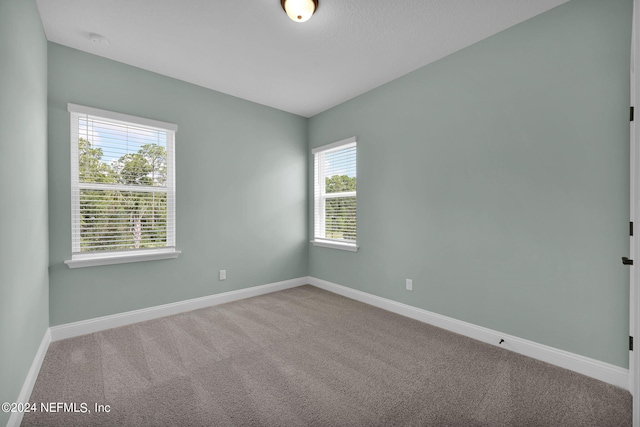 unfurnished room with carpet floors and baseboards