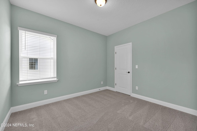 unfurnished room featuring carpet floors and baseboards