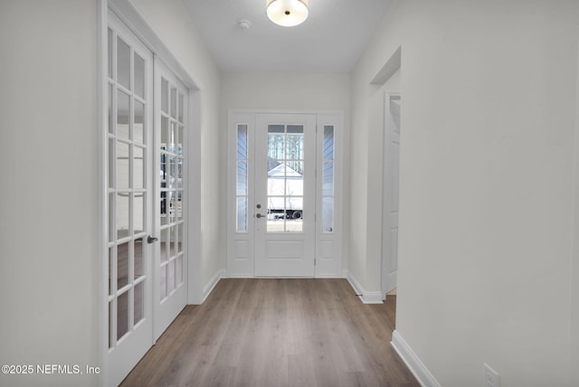 entryway with light hardwood / wood-style floors and french doors