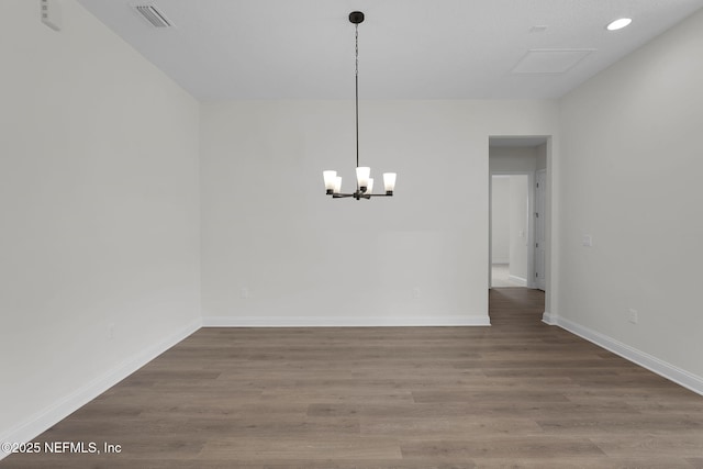 unfurnished dining area featuring a notable chandelier and wood-type flooring