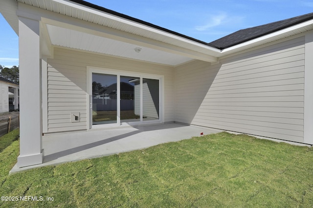 back of house with a patio and a lawn