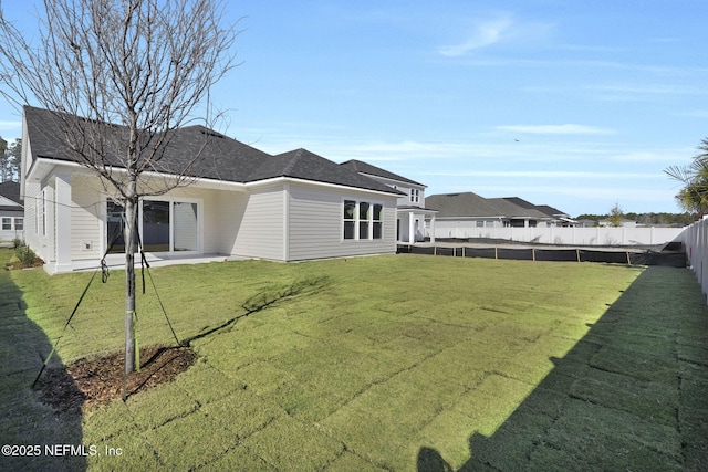 back of property with a yard and a patio area