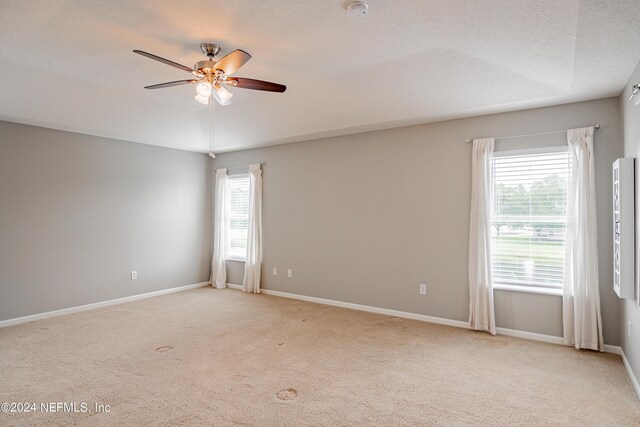 carpeted empty room with ceiling fan and a textured ceiling