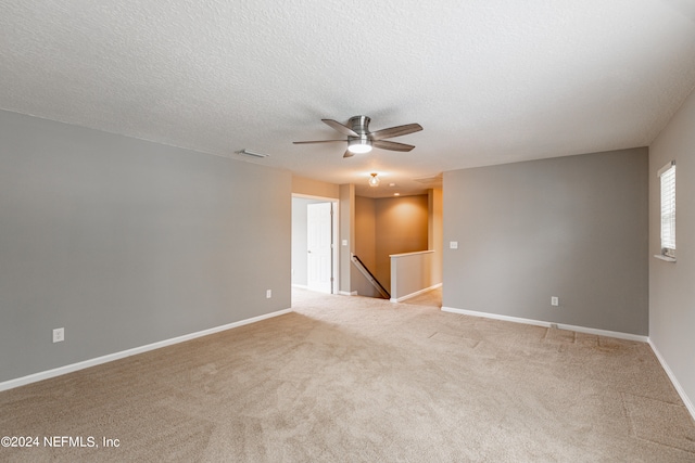 unfurnished room with light carpet, ceiling fan, and a textured ceiling