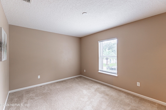 carpeted empty room with a textured ceiling