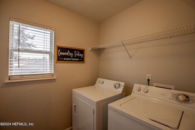 washroom with a wealth of natural light, a textured ceiling, and washer and clothes dryer