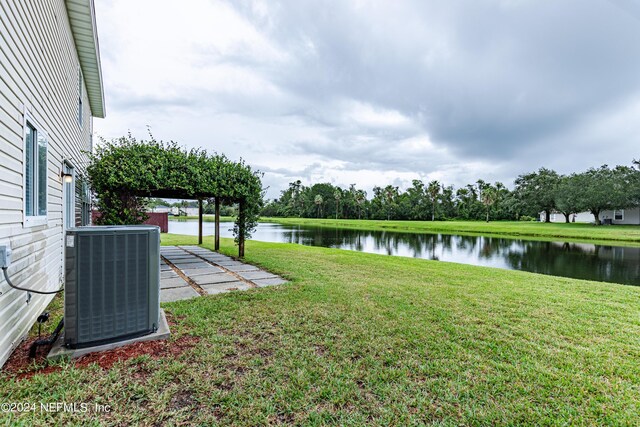 view of yard with a water view and central AC