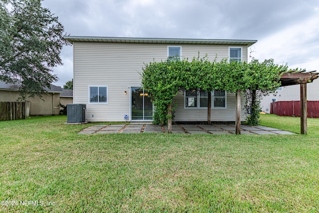 rear view of house with a pergola, a patio area, a yard, and cooling unit