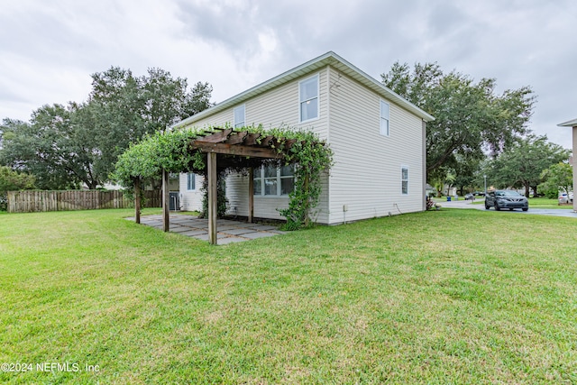 rear view of property featuring a lawn and a pergola