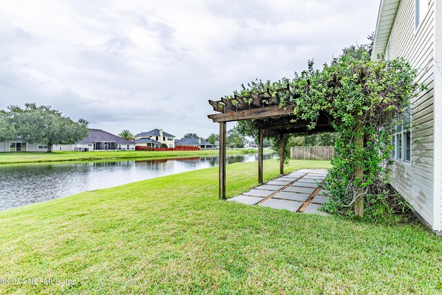 view of yard featuring a pergola, a patio area, and a water view