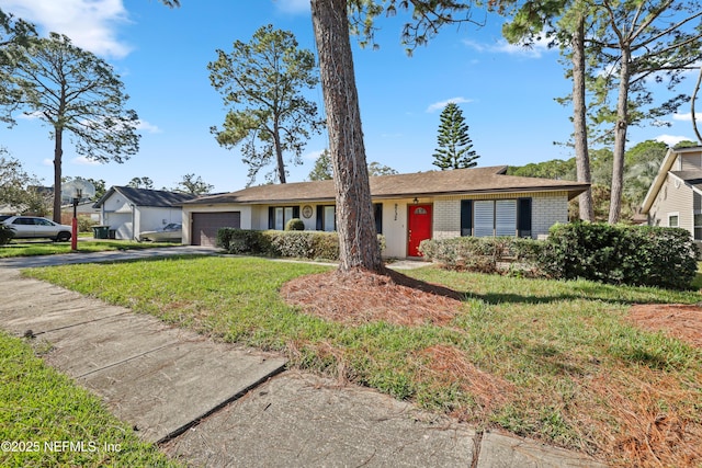 single story home with a garage and a front lawn