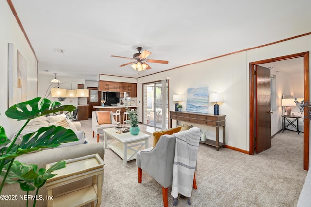 carpeted living room with ceiling fan and crown molding