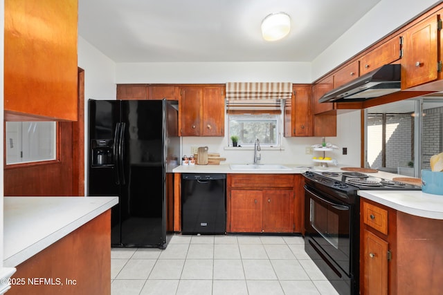 kitchen featuring sink, light tile patterned flooring, black appliances, and range hood