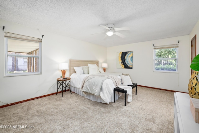 bedroom featuring ceiling fan, light carpet, and a textured ceiling