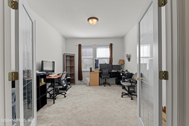 carpeted office space featuring a textured ceiling and french doors