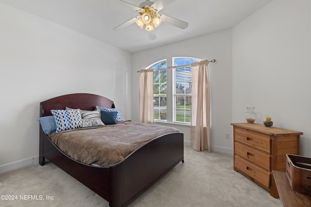 bedroom featuring baseboards, a ceiling fan, and light colored carpet