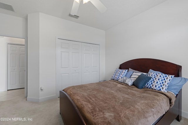 bedroom featuring a closet, visible vents, light carpet, and baseboards