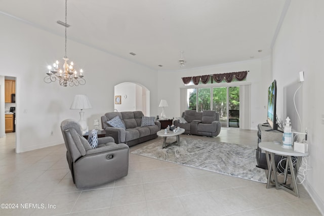 living area featuring arched walkways, light tile patterned floors, a high ceiling, baseboards, and an inviting chandelier