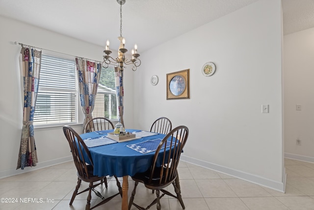 dining area with light tile patterned floors, baseboards, a chandelier, and a textured ceiling