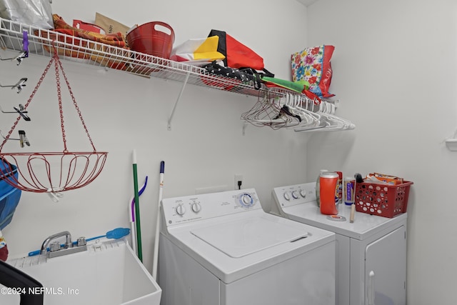 washroom featuring laundry area, washer and dryer, and a sink