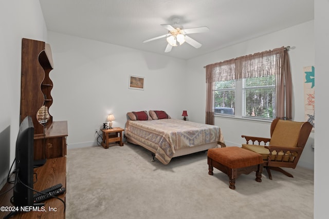 carpeted bedroom with ceiling fan and baseboards