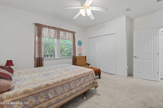 bedroom with baseboards, a ceiling fan, a closet, and light colored carpet