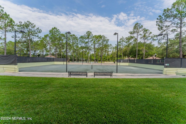 view of sport court featuring a yard and fence