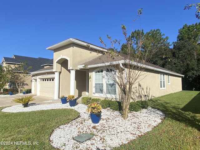 1912 White Dogwood Ln, Fleming Island, FL 32003 - view of front of home with a garage, driveway, a front yard, and stucco siding
