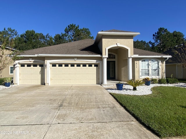 1912 White Dogwood Ln, Fleming Island, FL 32003 - single story home featuring roof with shingles, a front yard, concrete driveway, an attached garage, and stucco siding
