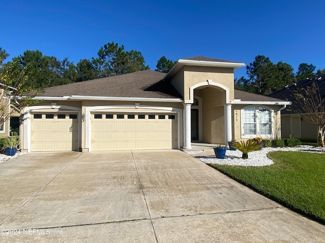 view of front of house with concrete driveway, a shingled roof, an attached garage, and stucco siding