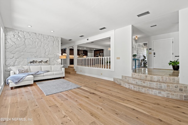 living area with visible vents, stairway, and wood finished floors